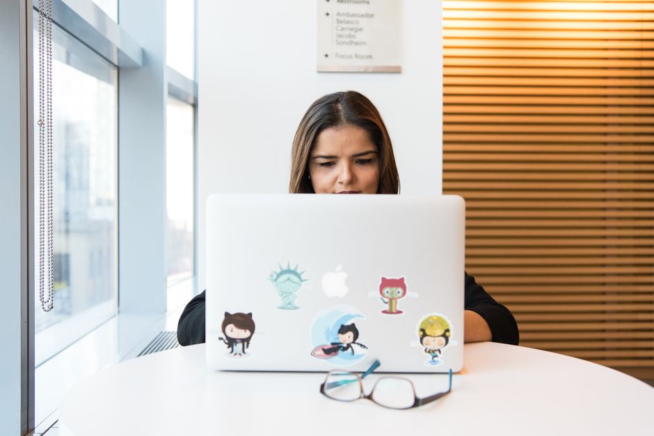 Femme concentrée travaillant sur le développement de logiciels à distance sur un ordinateur portable en intérieur.