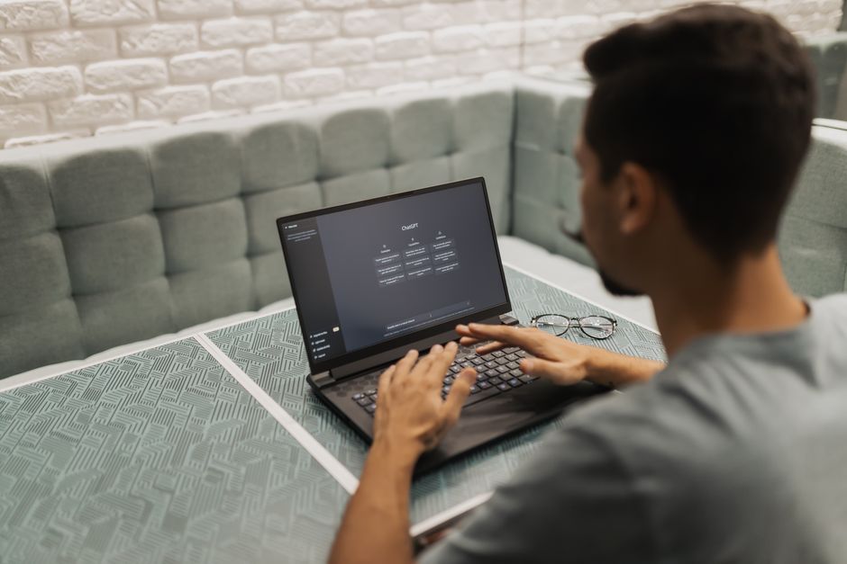 Homme travaillant sur un ordinateur portable dans un espace de bureau moderne et confortable, mettant l'accent sur la technologie.
