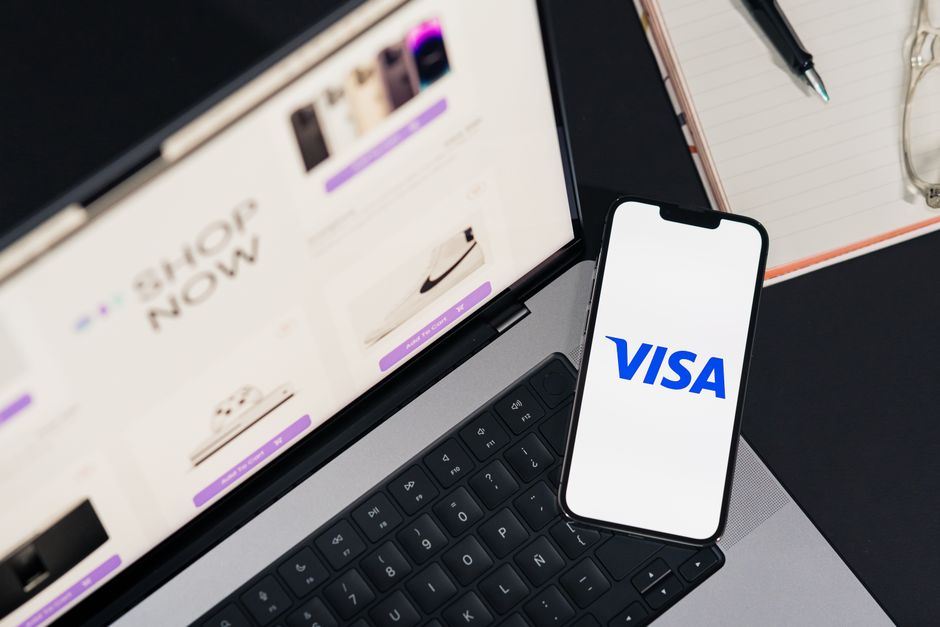 Smartphone affichant VISA sur un ordinateur portable pour une expérience d'achat en ligne.