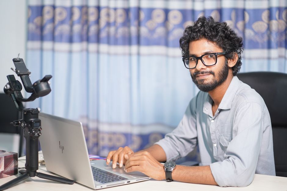 Portrait d'un développeur web travaillant sur un ordinateur portable, mettant en avant ses compétences techniques et professionnelles.