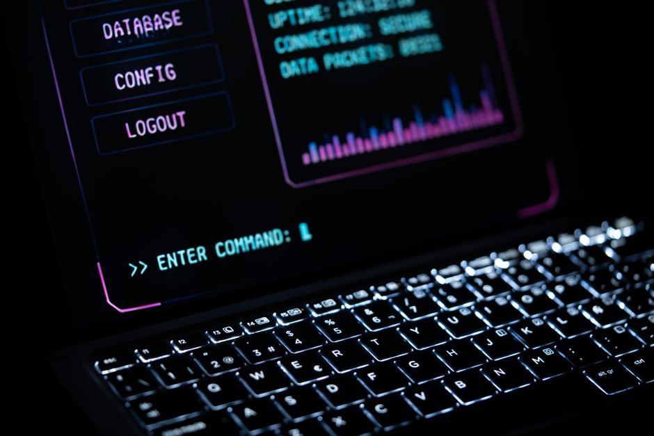 Gros plan sur un clavier d'ordinateur portable lumineux avec une interface numérique, représentant une technologie futuriste.