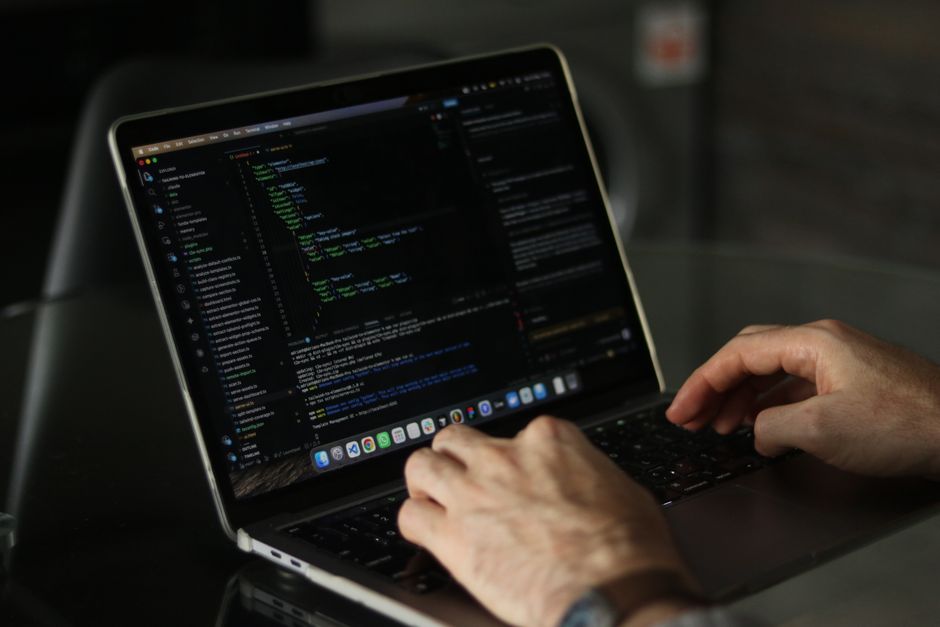 Gros plan sur des mains programmant sur un ordinateur portable, illustrant la productivité en développement.