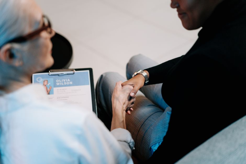 Deux femmes professionnelles se serrant la main dans un bureau, illustrant le recrutement et la connexion.