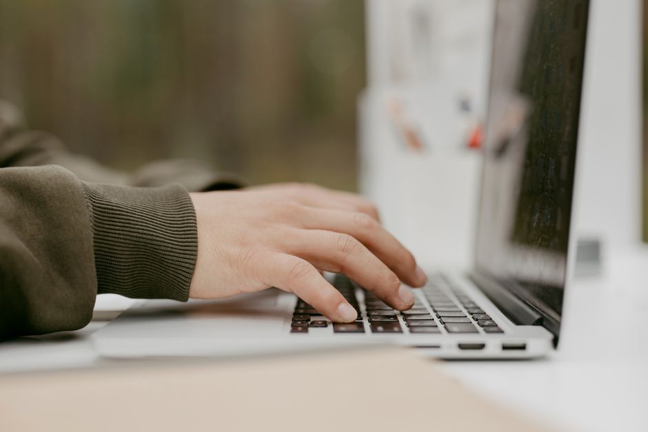 Gros plan sur des mains tapant sur le clavier d'un ordinateur portable, idéal pour les thèmes technologiques et le style de vie.