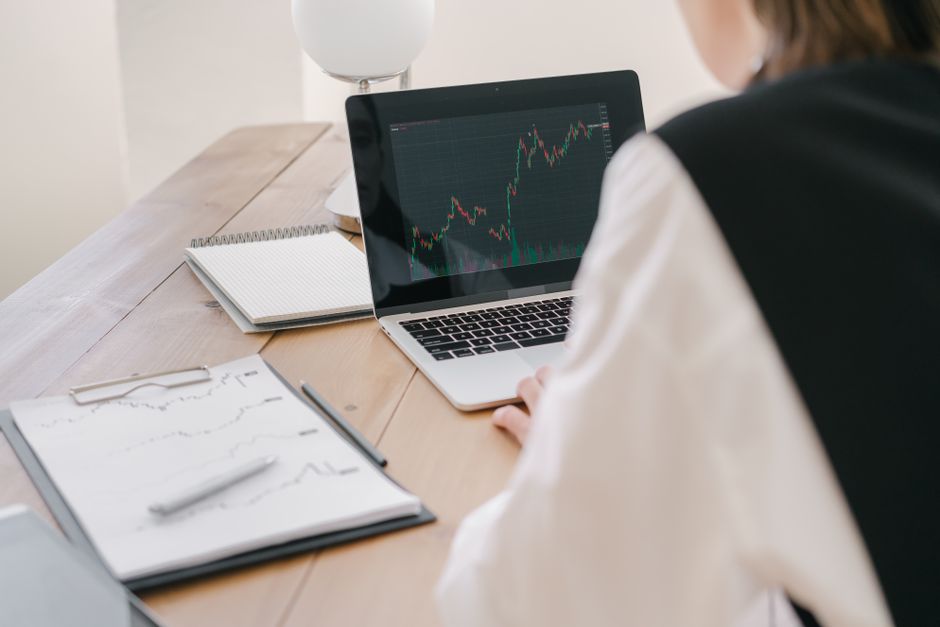 Un professionnel analysant les tendances boursières sur un ordinateur portable dans un bureau.