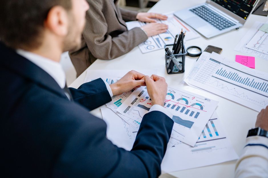 Équipe commerciale analysant des graphiques financiers autour d'une table de réunion, favorisant la collaboration dans un environnement de bureau.