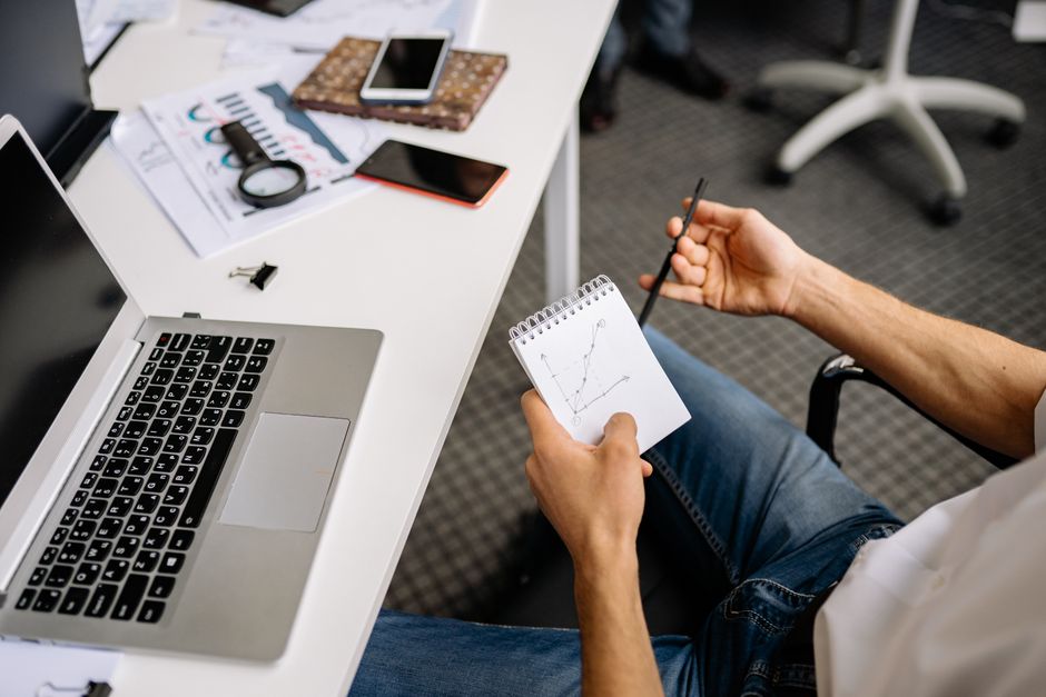 Homme d'affaires examinant un graphique linéaire dans un espace de bureau moderne.