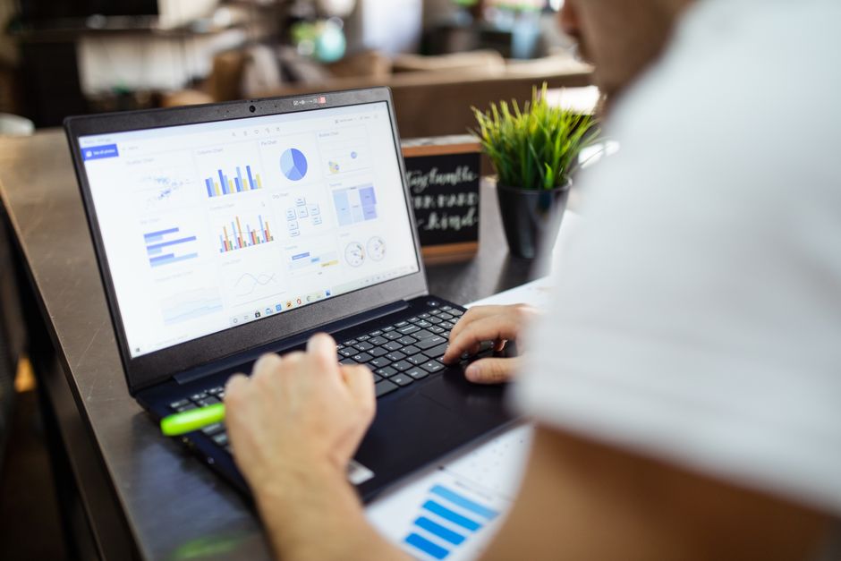 Analyse commerciale concentrée avec des graphiques sur un ordinateur portable dans un bureau moderne.