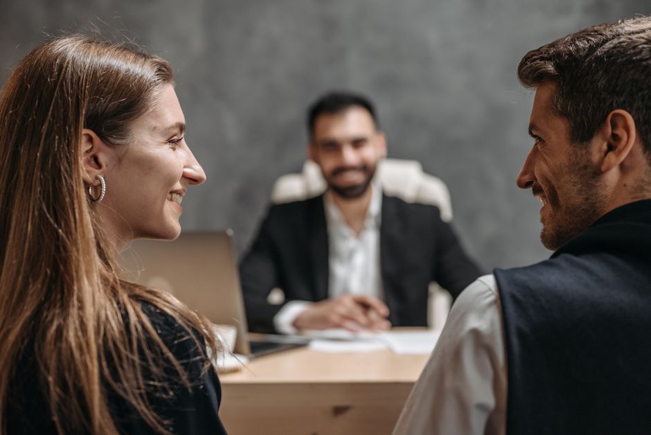 Réunion d'affaires conviviale avec des professionnels souriants assis dans un bureau.