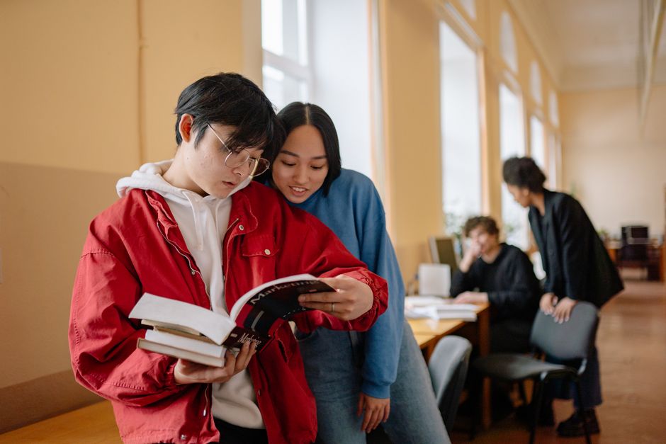 Groupe d'étudiants lisant et étudiant ensemble dans une bibliothèque.